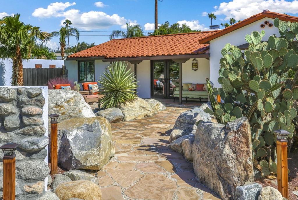 um quintal com cactos e pedras e uma casa em Casa Rosa - A Ryson Property em Palm Springs
