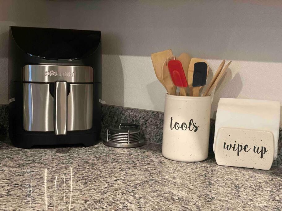 a kitchen counter with a coffee maker and a cup with utensils at Sleek & Stylish 3-BR Luxury Townhome - 7 Mile from Las Vegas Strip in Las Vegas