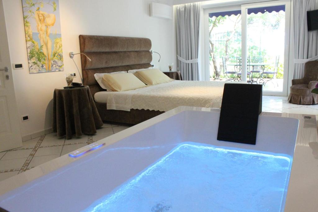 un bagno con vasca nel centro della camera da letto di Villa Marinella a Ischia