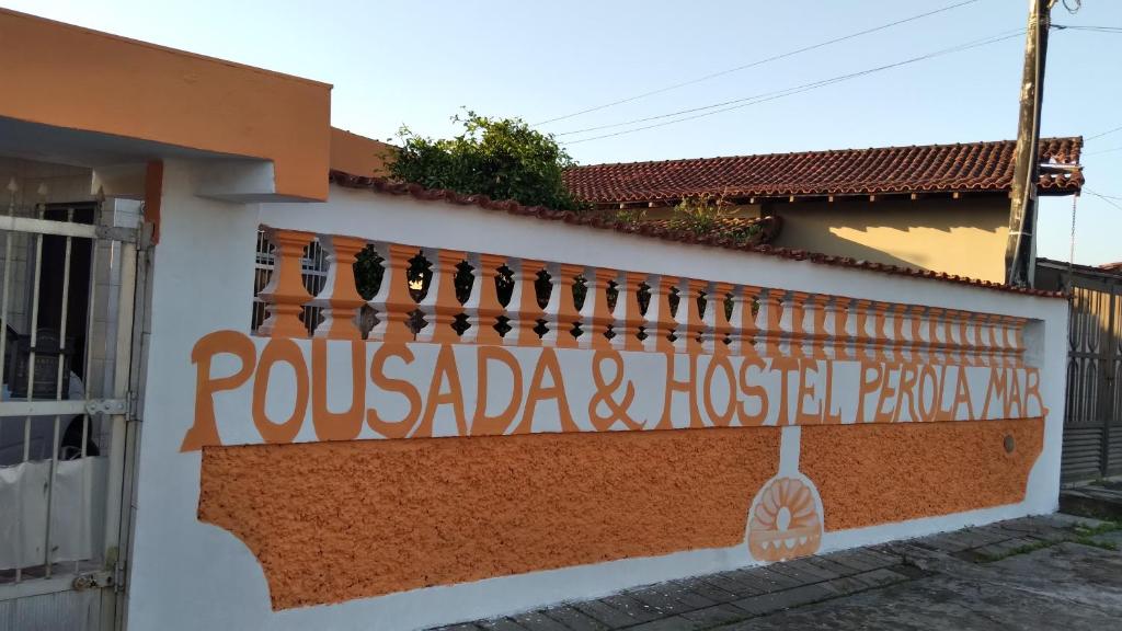 a building with a sign on the side of it at pousada&Hostel perola mar in Mongaguá