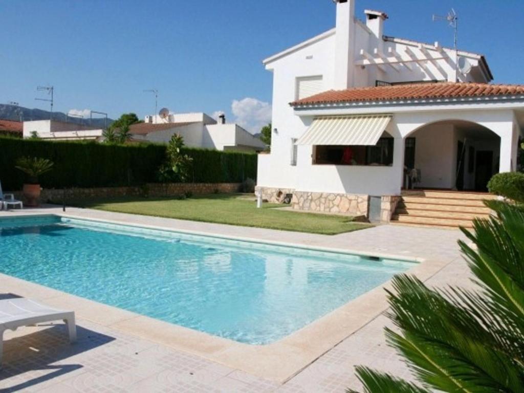 uma villa com piscina em frente a uma casa em Villa L'Ametlla de Mar, 5 pièces, 8 personnes - HISP-217-213 em L'Ametlla de Mar