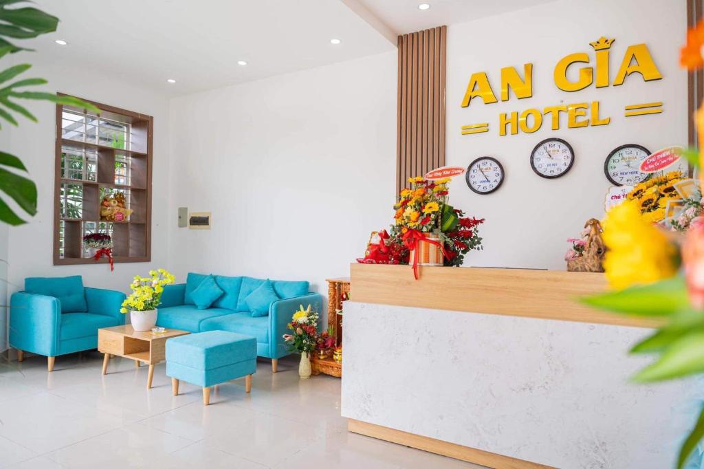 an ala hotel lobby with blue chairs and clocks at An Gia Hotel Tây Ninh in Tây Ninh