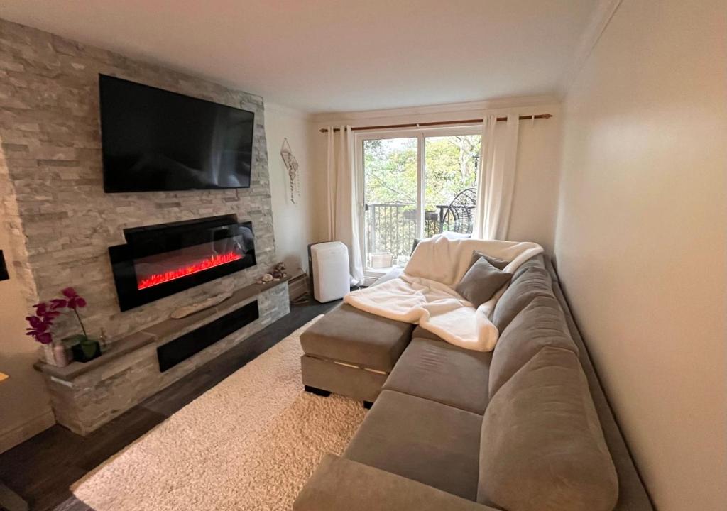 ein Wohnzimmer mit einem Sofa und einem Flachbild-TV in der Unterkunft Ocean Villa -1BDR- King bed- Kitsilano beach w/parking in Vancouver