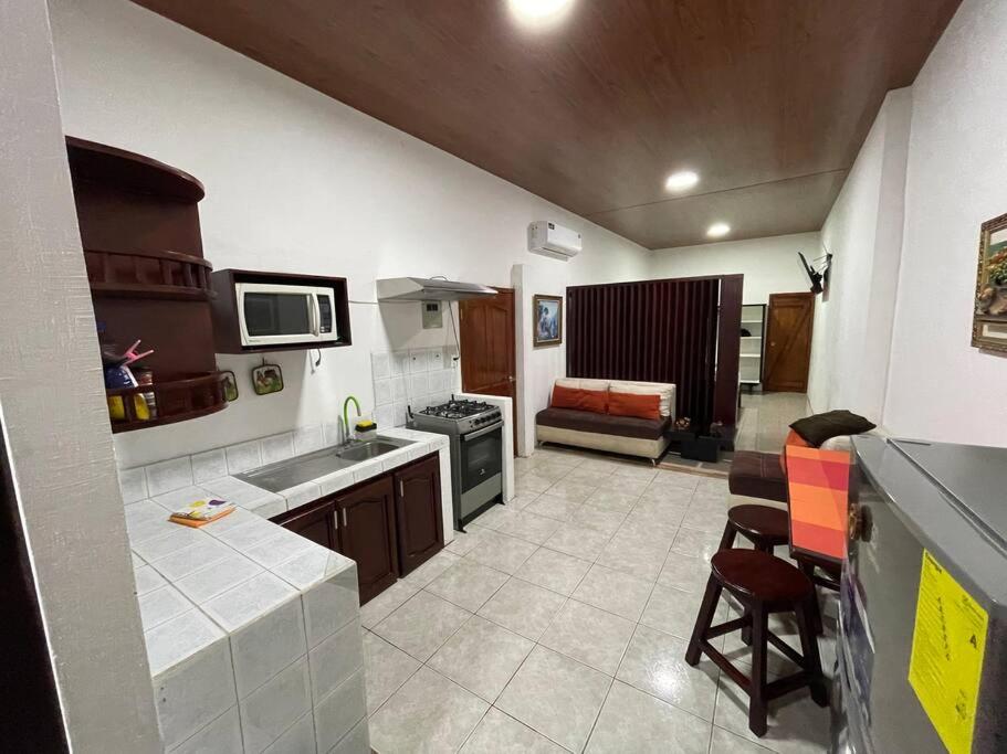 eine Küche mit einem Waschbecken und einem Sofa in einem Zimmer in der Unterkunft Family Apart Studio in Puerto Baquerizo Moreno