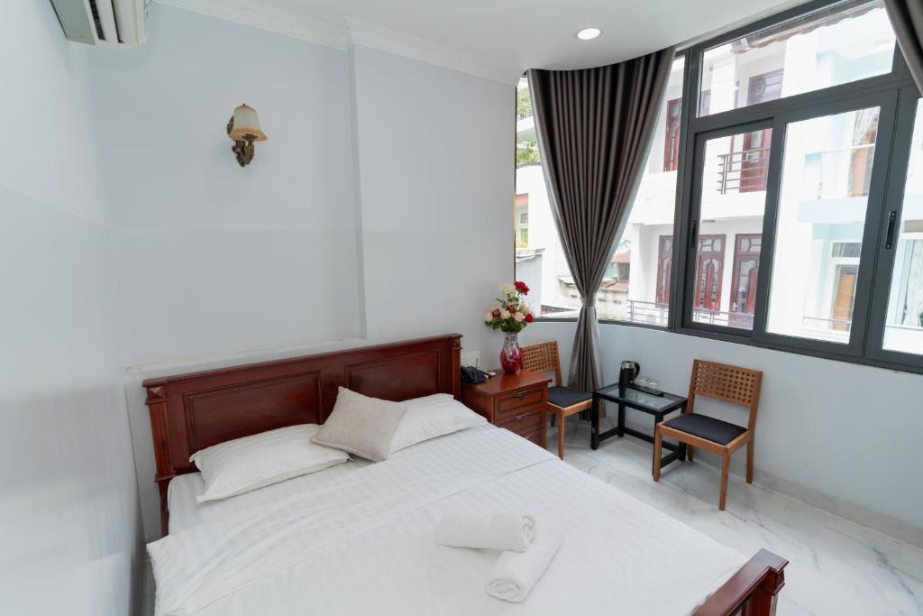Un dormitorio con una gran cama blanca y una ventana. en Sunny Guesthouse2, en Ho Chi Minh