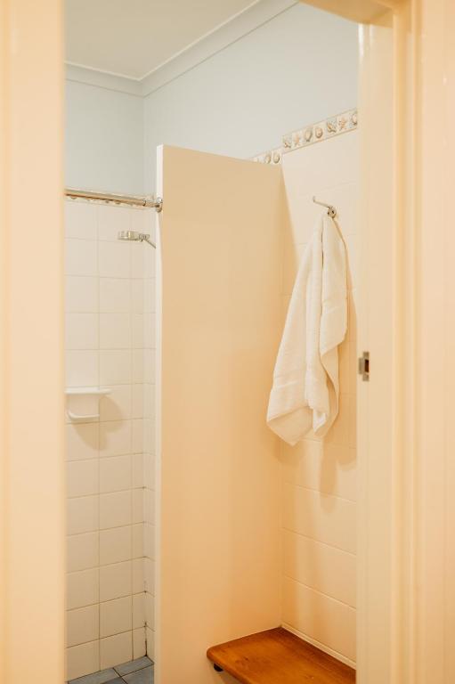 a bathroom with a shower and a white towel at Ceduna Foreshore Hotel Motel in Ceduna