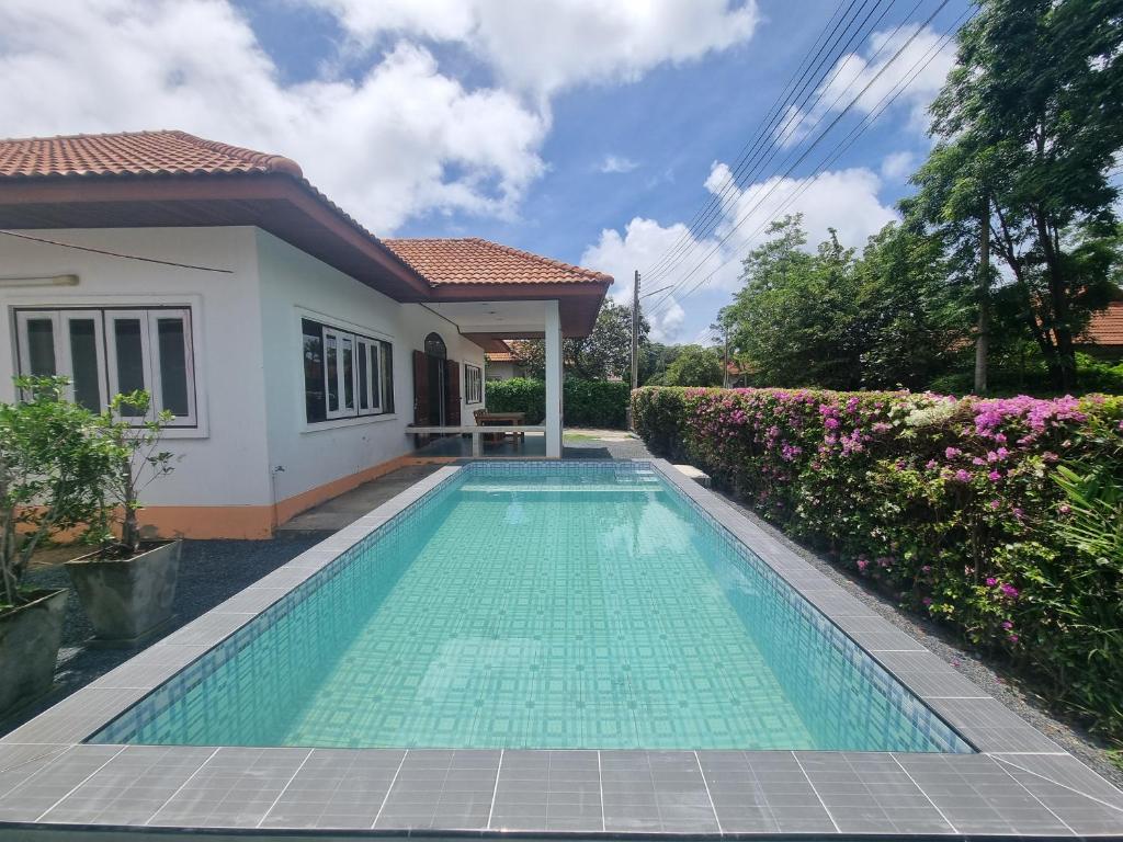 a swimming pool in front of a house at Mae Rampung Beach House Pool Villa in Rayong