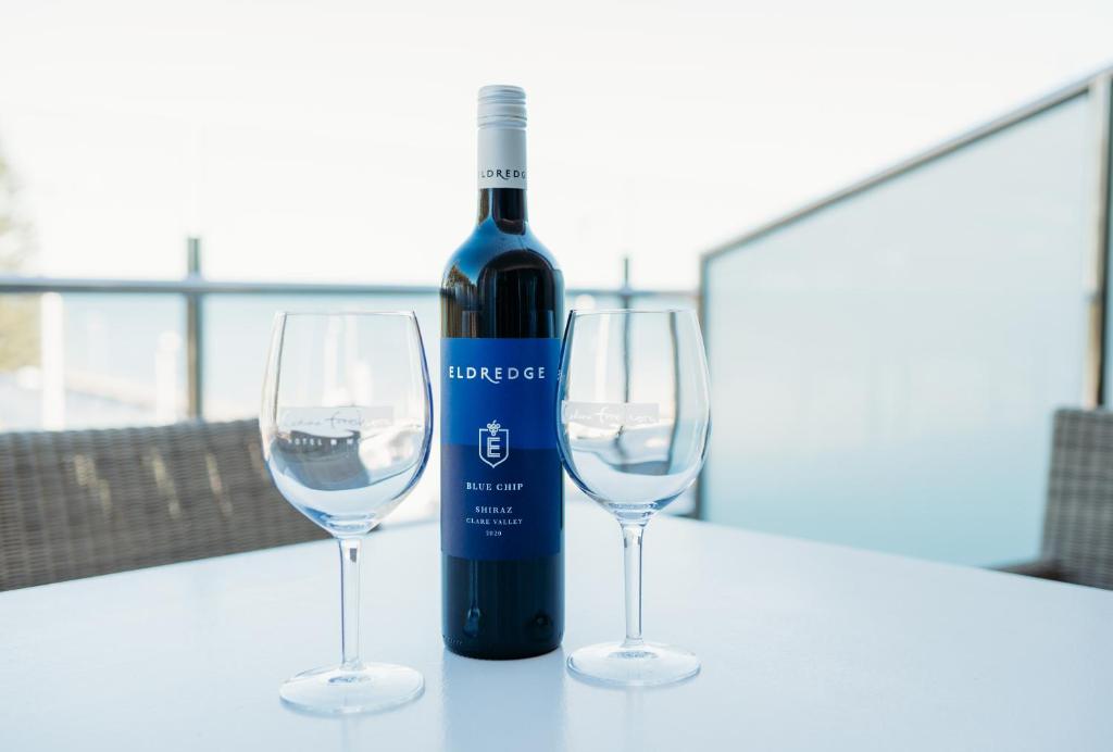 a bottle of wine and two wine glasses on a table at Ceduna Foreshore Hotel Motel in Ceduna