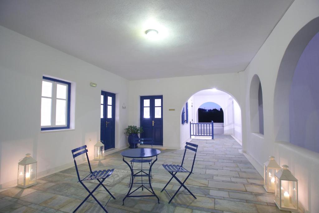 a room with a table and chairs and a hallway at Paros Inn Seafront in Logaras