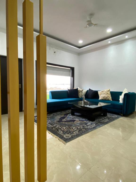a living room with a blue couch and a table at Amritsar Homes - A perfect home away from home in Amritsar