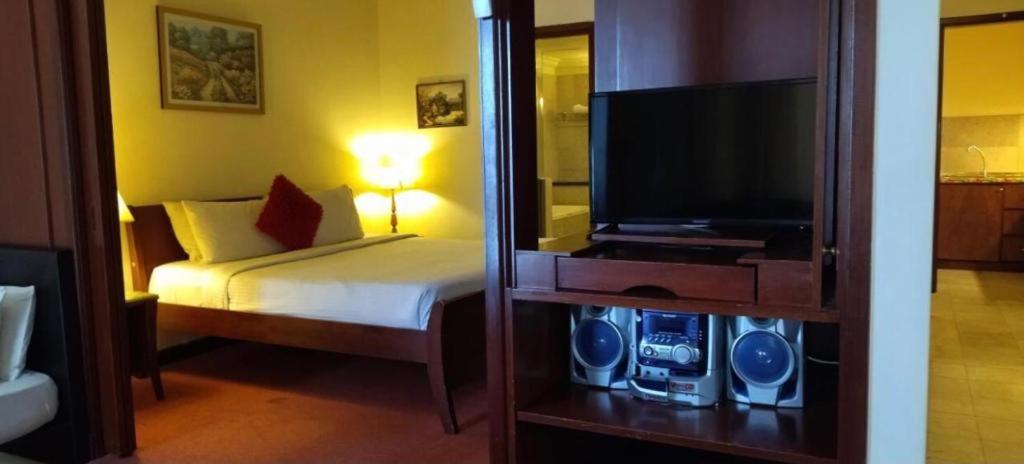 Schlafzimmer mit einem Bett und einem Flachbild-TV in der Unterkunft AmyliaLee service suit berjaya time square at kl in Kuala Lumpur