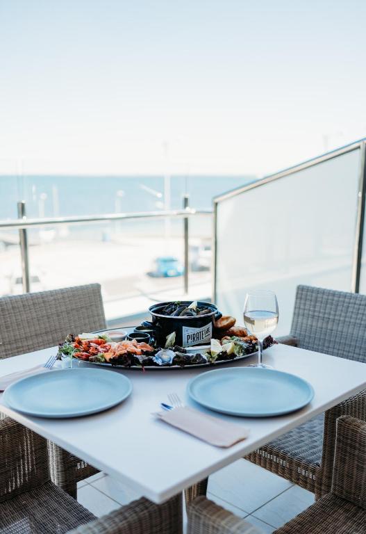 a table with a plate of food and a wine glass at Ceduna Foreshore Hotel Motel in Ceduna