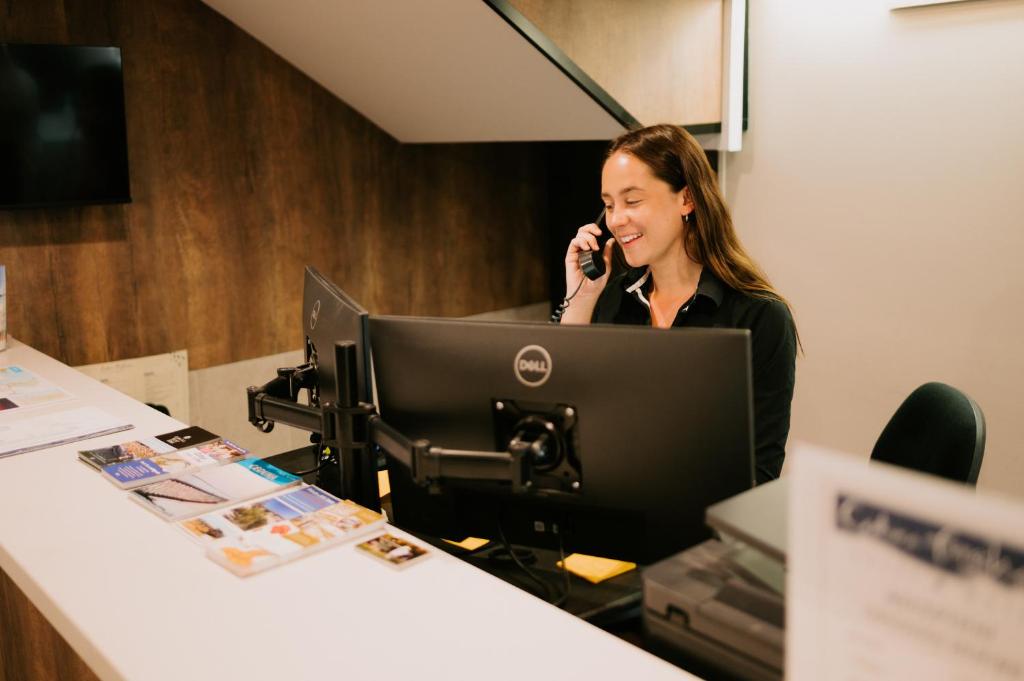 a woman sitting at a desk talking on a phone at Ceduna Foreshore Hotel Motel in Ceduna
