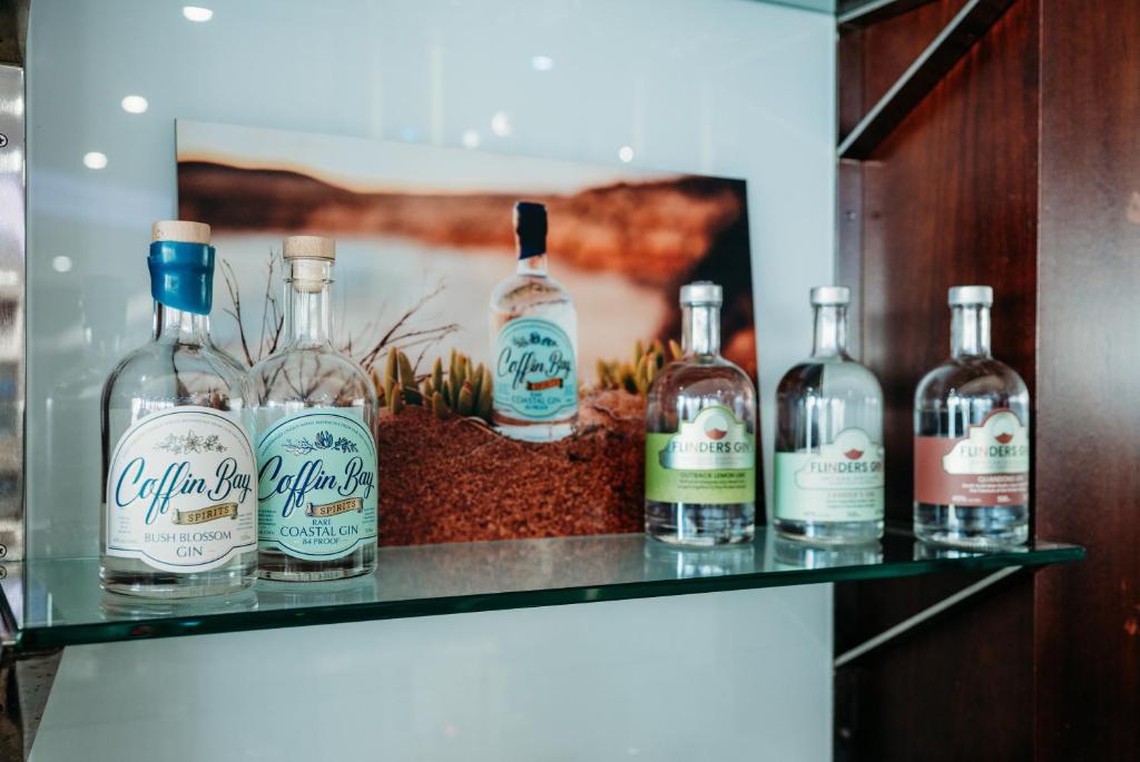 a shelf with four bottles of alcohol on it at Ceduna Foreshore Hotel Motel in Ceduna