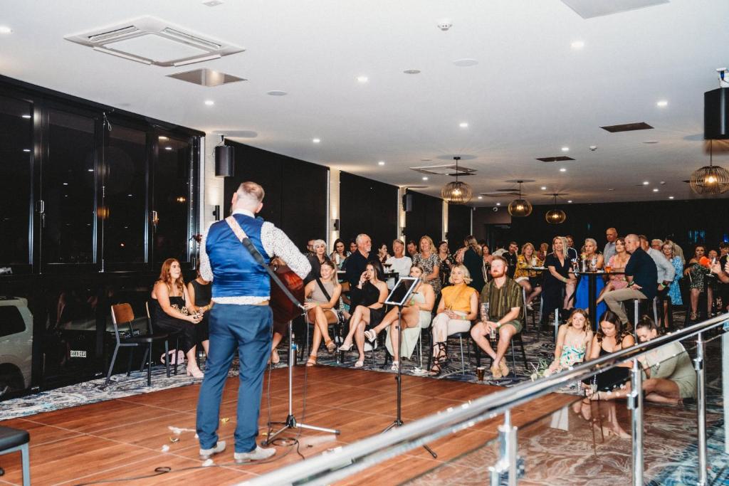a man standing on a stage in front of a crowd at Ceduna Foreshore Hotel Motel in Ceduna