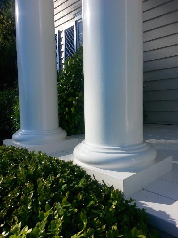 two white columns in front of a house at Belle Maison Auprès De La Mer in Sidney