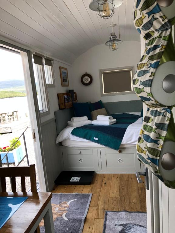 a bedroom with a bed and a view of the ocean at Fisherman's Hut in Tarbert