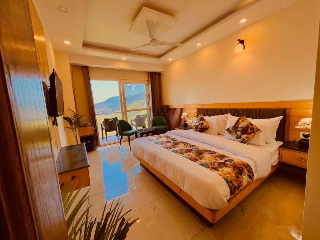 Habitación de hotel con cama grande y TV en Hotel Pinerock & Cafe, Mussoorie - Mountain View Luxury Rooms with open Rooftop Cafe en Mussoorie