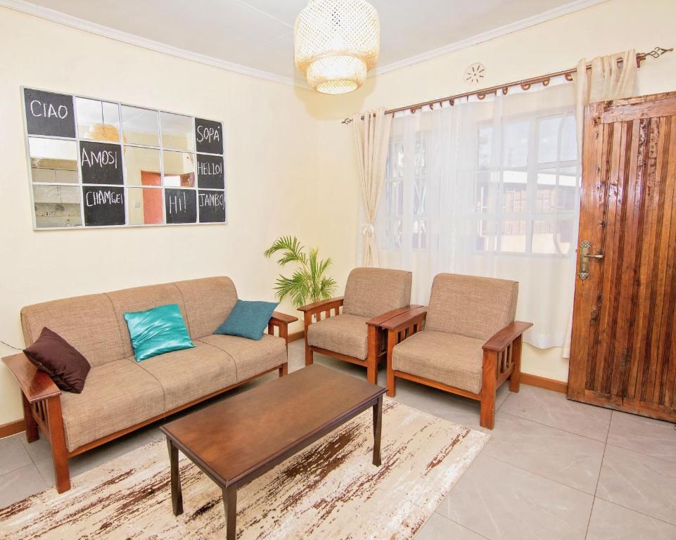 un soggiorno con divano e 2 sedie di Ebony Mara a Narok