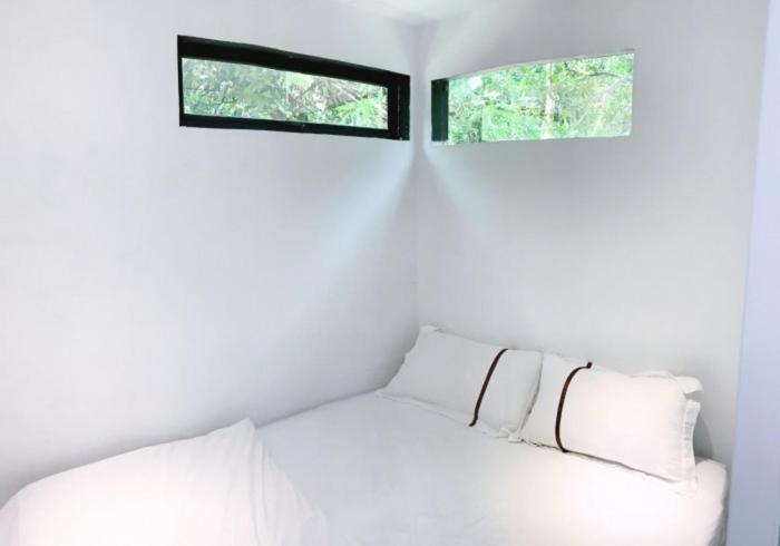 Cama blanca en habitación con 2 ventanas en Time Capsule Retreat, Sungai Lembing, en Sungai Lembing