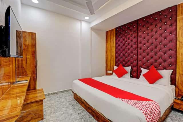 Un dormitorio con una cama grande con cabecero rojo. en HOTEL GK VILLA, en Ahmedabad