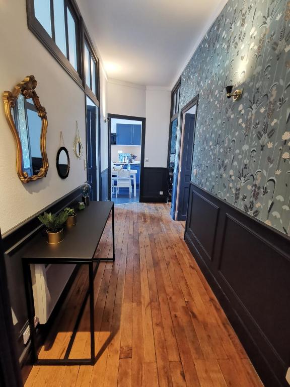 - un salon avec une table et un miroir dans l'établissement Charmant appartement proche de la gare, à Vichy