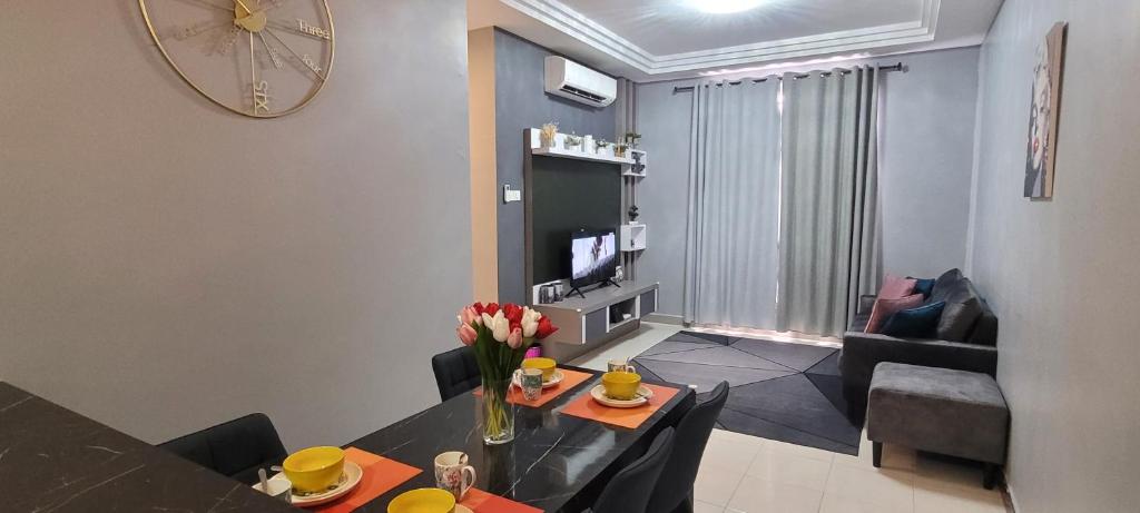 un salon avec une table à manger et un salon avec une horloge dans l'établissement Ipoh homestay Casa, à Ipoh