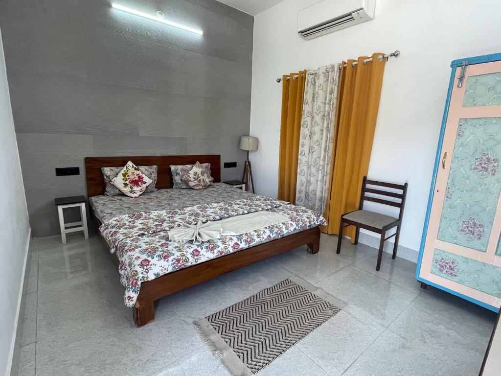 1 dormitorio con 1 cama y 1 silla en Atithya, en Udaipur