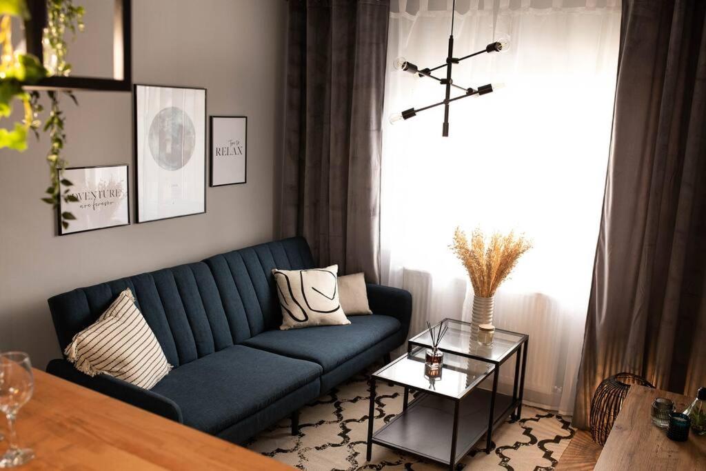 uma sala de estar com um sofá azul e uma mesa em blue moon. cozy apartment near Iulius Mall em Cluj-Napoca