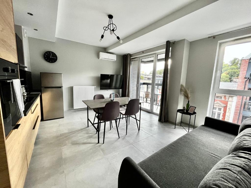 a kitchen and living room with a table and chairs at City Center Apartments z parkingiem in Bydgoszcz