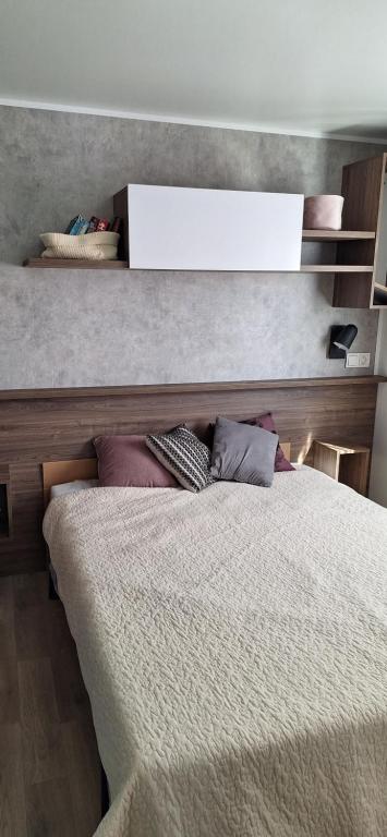 ein Schlafzimmer mit einem Bett mit einem Whiteboard darüber in der Unterkunft Camping SIBLU - La réserve in Gastes