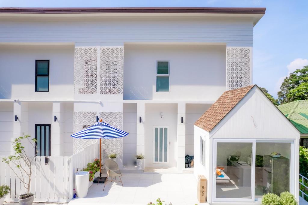 Casa blanca con patio y sombrilla en Koh Chang Luxury Pool Villas, en Ko Chang