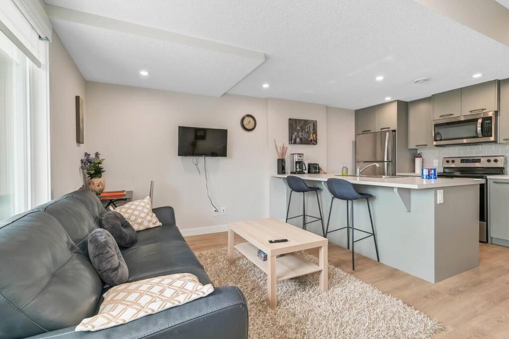 a living room with a couch and a kitchen at Brand New Executive Suite in Calgary