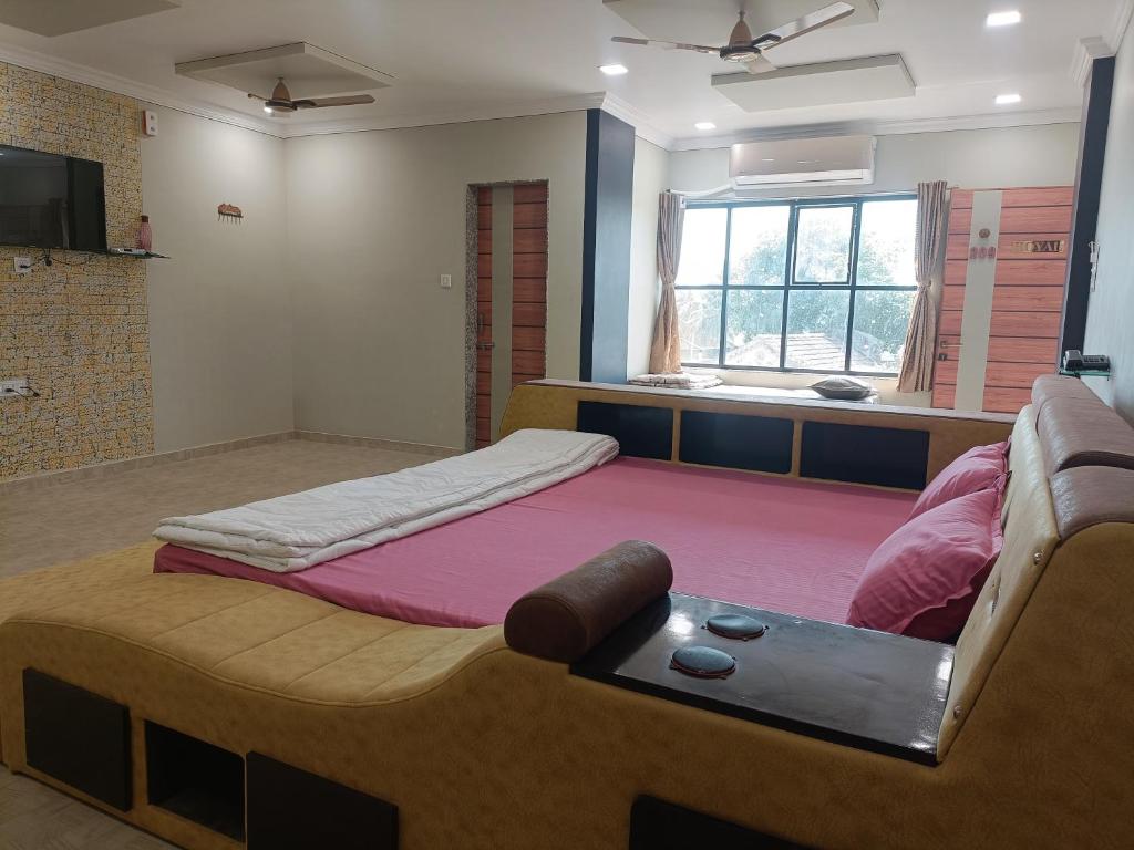 1 dormitorio con 1 cama grande y 1 sofá en HOTEL JB STAR en Mandvi
