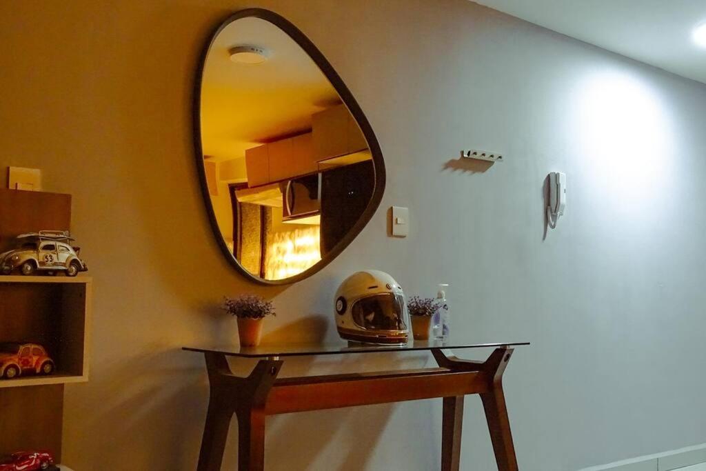 un espejo en una pared junto a una mesa con un casco en Acogedor y moderno Loft en Cholula, en Santa María Tonantzintla