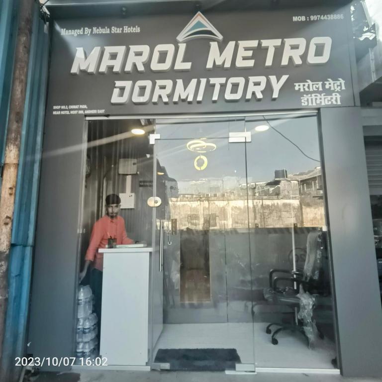 a man standing at a counter in a store window at Marol Metro Dormitory in Mumbai