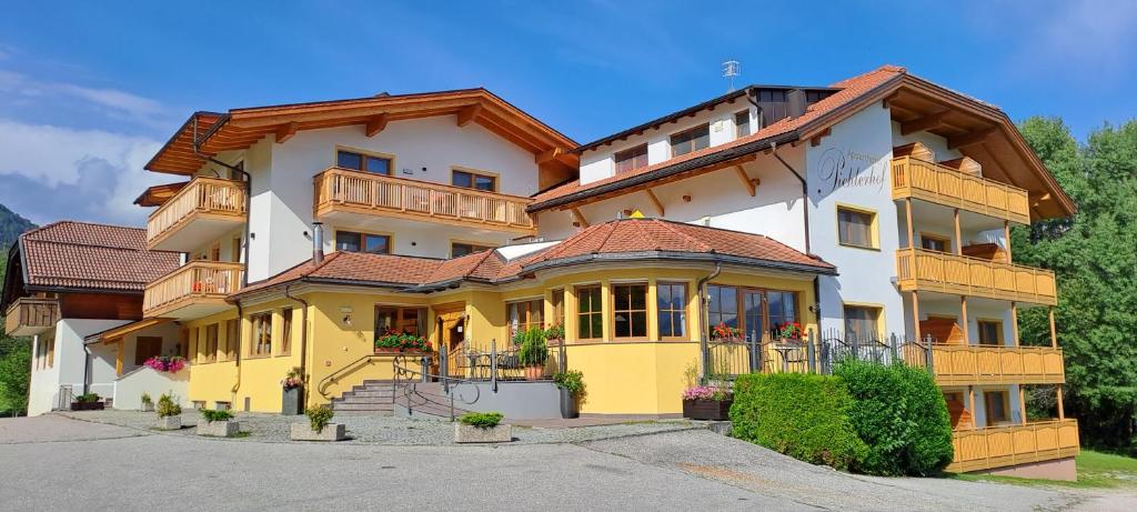 duży żółto-biały budynek z balkonem w obiekcie Apartment Pichlerhof w mieście San Lorenzo di Sebato