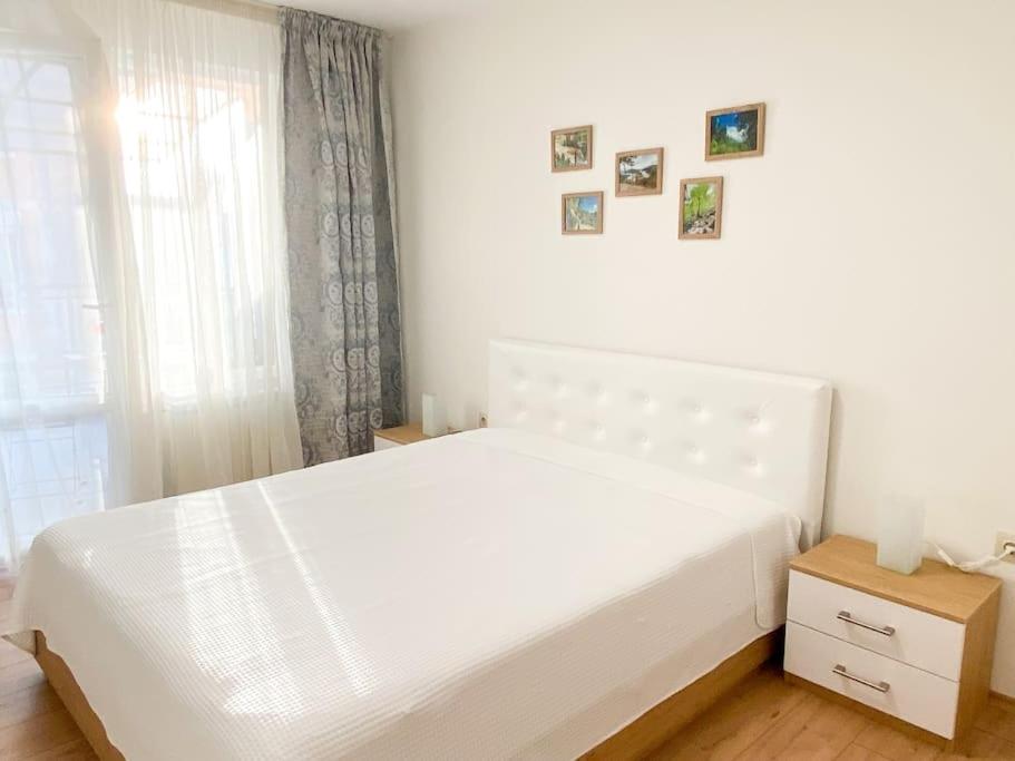 a white bed in a bedroom with a window at Maryland Apartment in Sofia