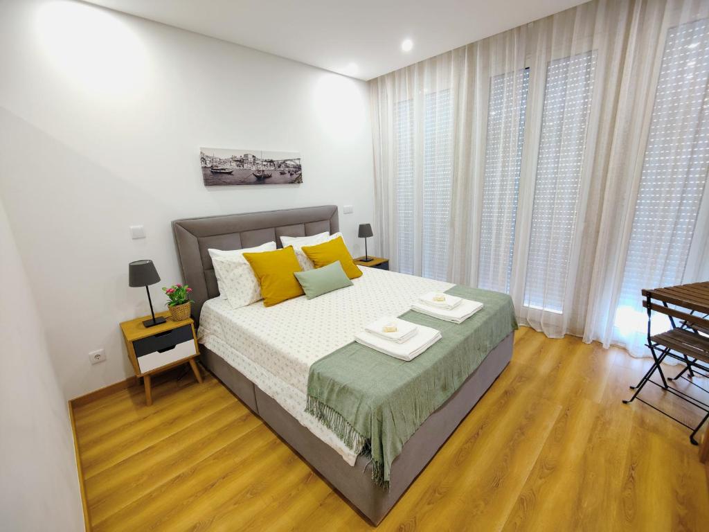 a bedroom with a large bed with yellow pillows at Apartment in the historic center of Porto in Porto