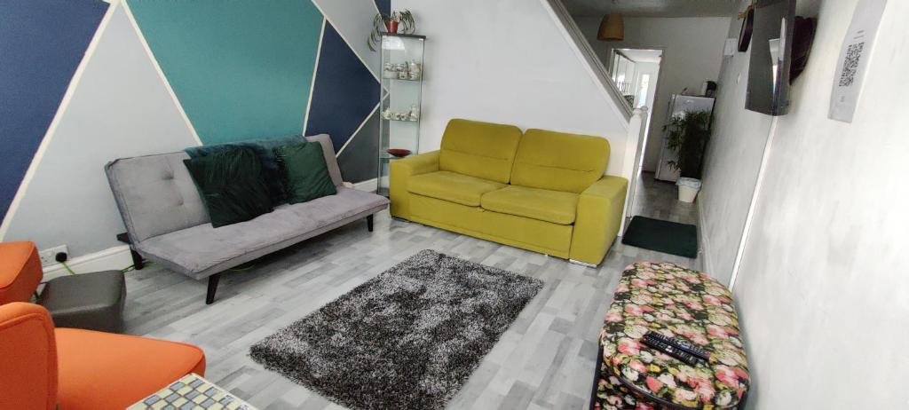 a living room with a yellow chair and a couch at House with great location near Harry Potter studio in Watford
