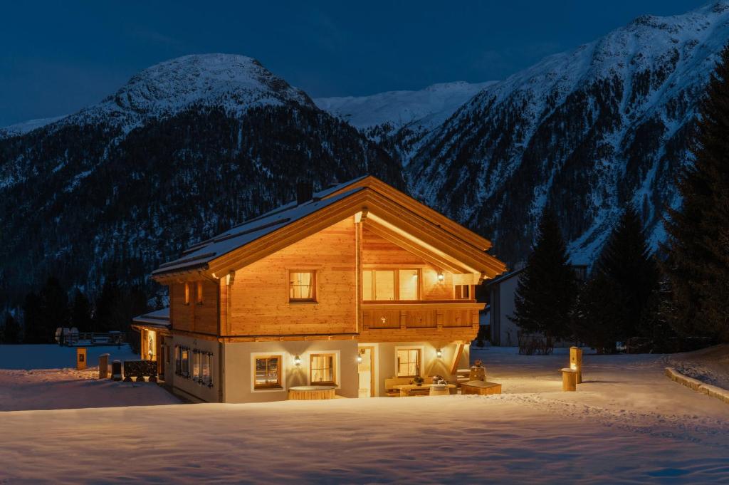 ein Blockhaus im Schnee mit Bergen im Hintergrund in der Unterkunft Engadin Chalet - Private Spa Retreat & Appart -St Moritz - Val Bever in Bever