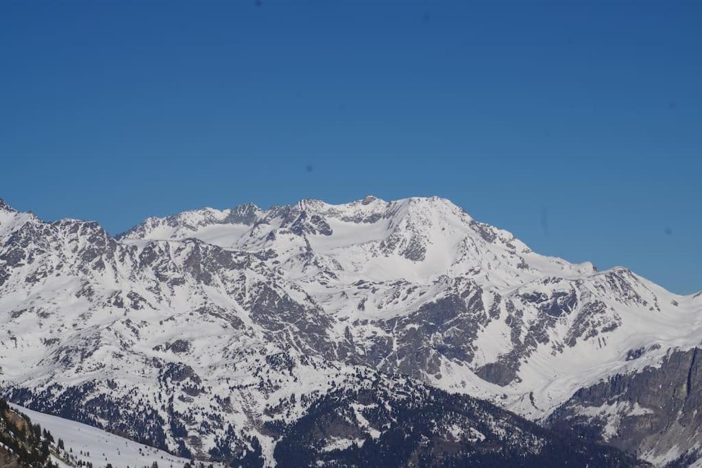 a snow covered mountain with a blue sky in the background at Superbe appartement à Valfréjus in Valfréjus