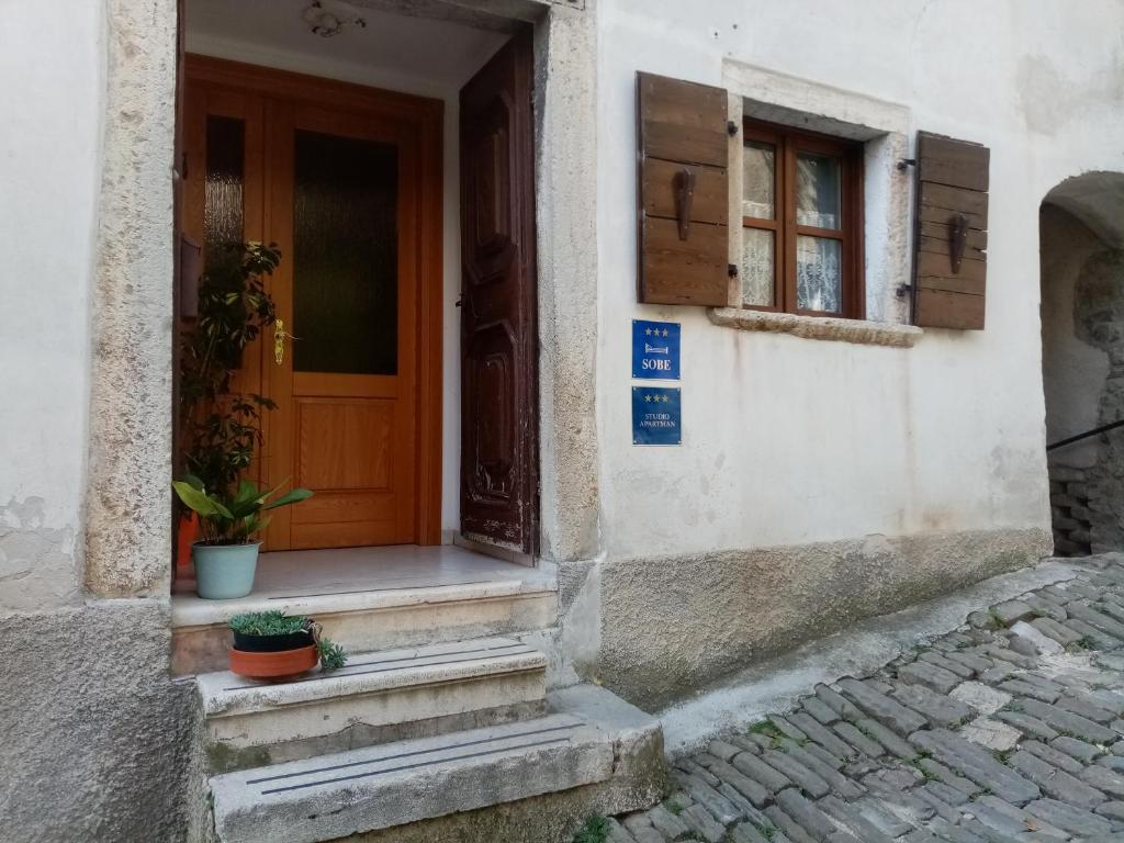 wejście do domu z drewnianymi drzwiami w obiekcie Rooms Serafin w mieście Motovun