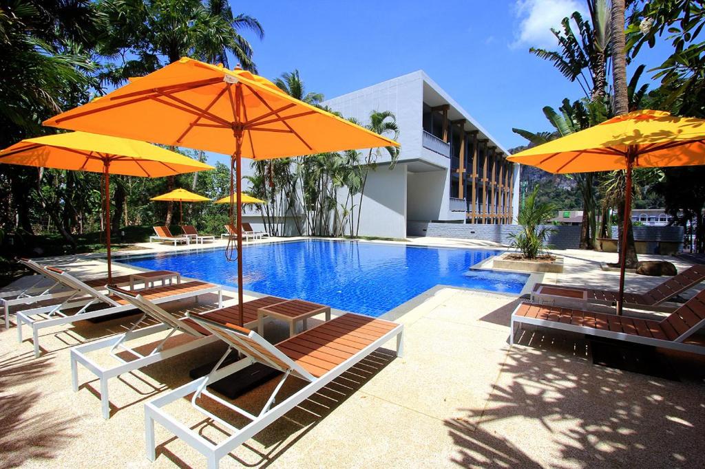 a group of chairs and umbrellas next to a swimming pool at Marina Express-Fisherman Aonang in Ao Nang Beach