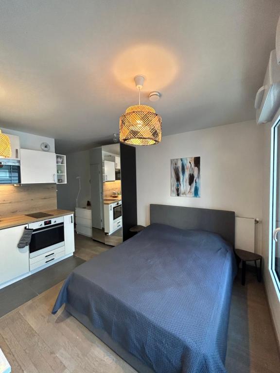 een slaapkamer met een blauw bed in een kamer bij Studio Design & Cosy avec Parking in Issy-les-Moulineaux