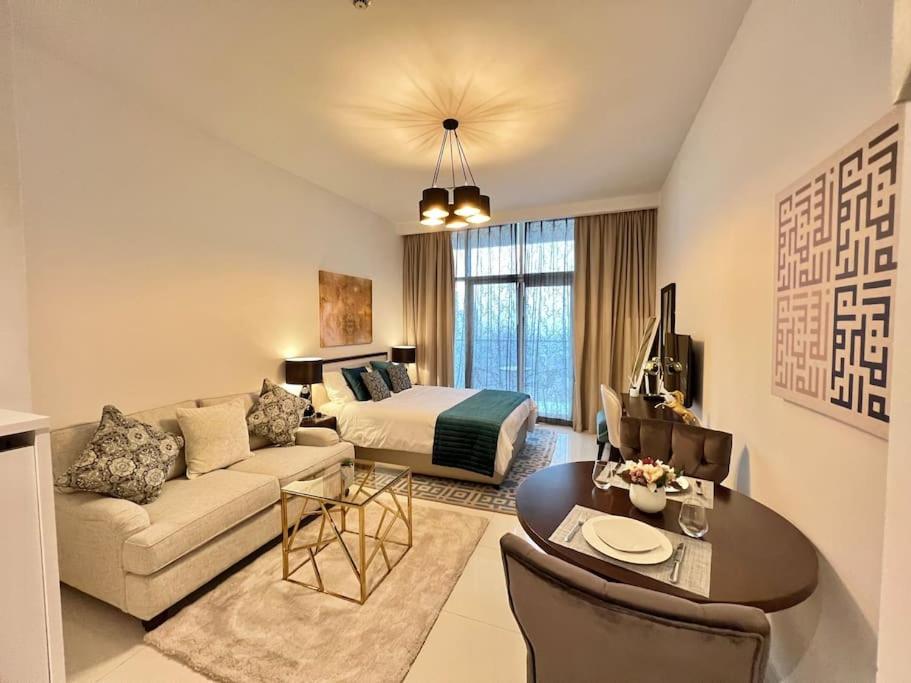 Una habitación de hotel con una cama y una sala de estar. en Ghalia Damac Studio Apartment, en Dubái