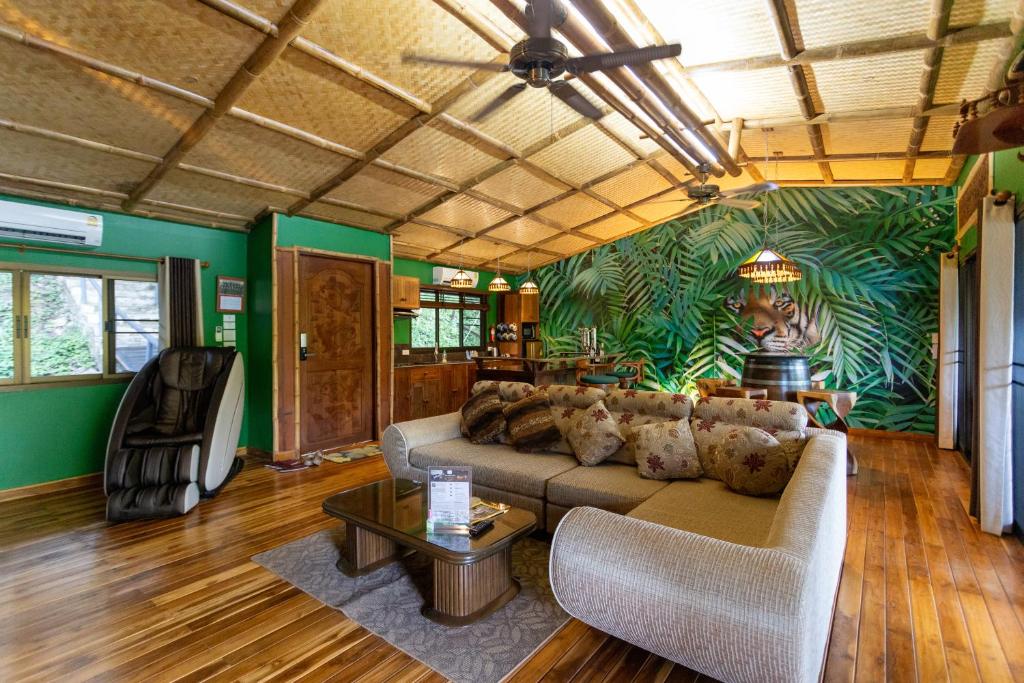 ein Wohnzimmer mit einem Sofa und einem Tisch in der Unterkunft The Parrot Inn Kanchanaburi in Kanchanaburi