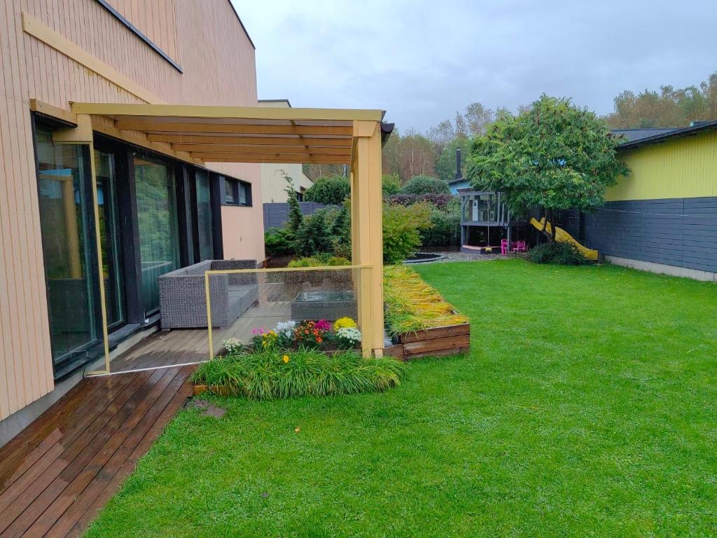 a garden with a pergola next to a building at Rentida luxuslik maja. in Tallinn