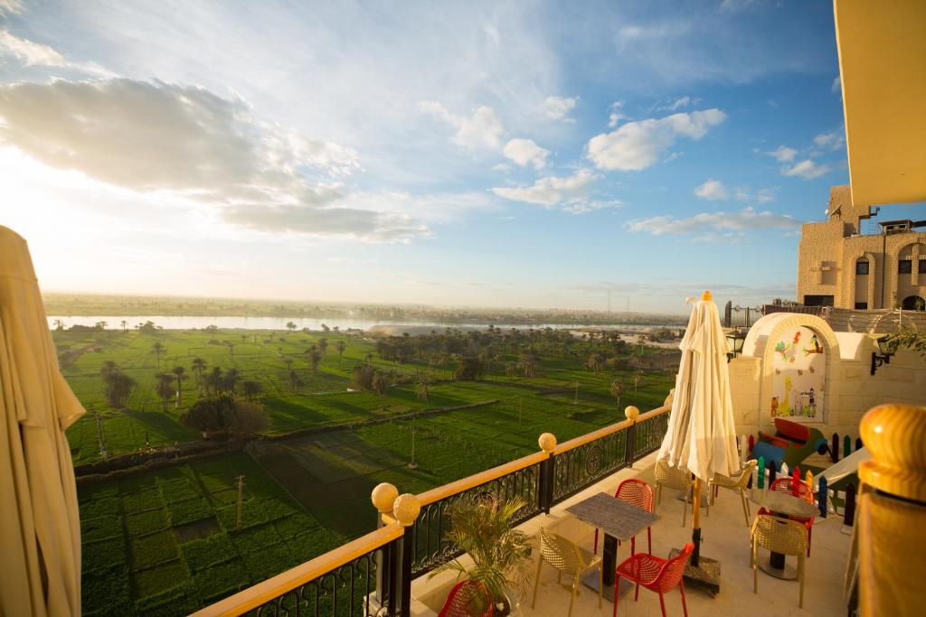 a balcony with a view of a green field at Holy Family Hotel in Jabal aţ Ţayr
