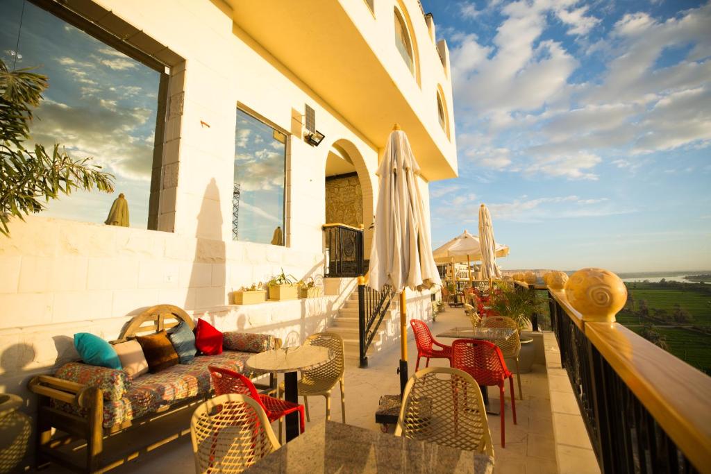 a balcony with a couch and tables and chairs at Holy Family Hotel in Jabal aţ Ţayr